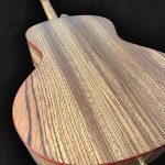 Guitare acoustique jumbo avec ouverture sur le côté, orientée vers le musicien en bois clair épicéa du Jura, Zebrano et liseré rouge