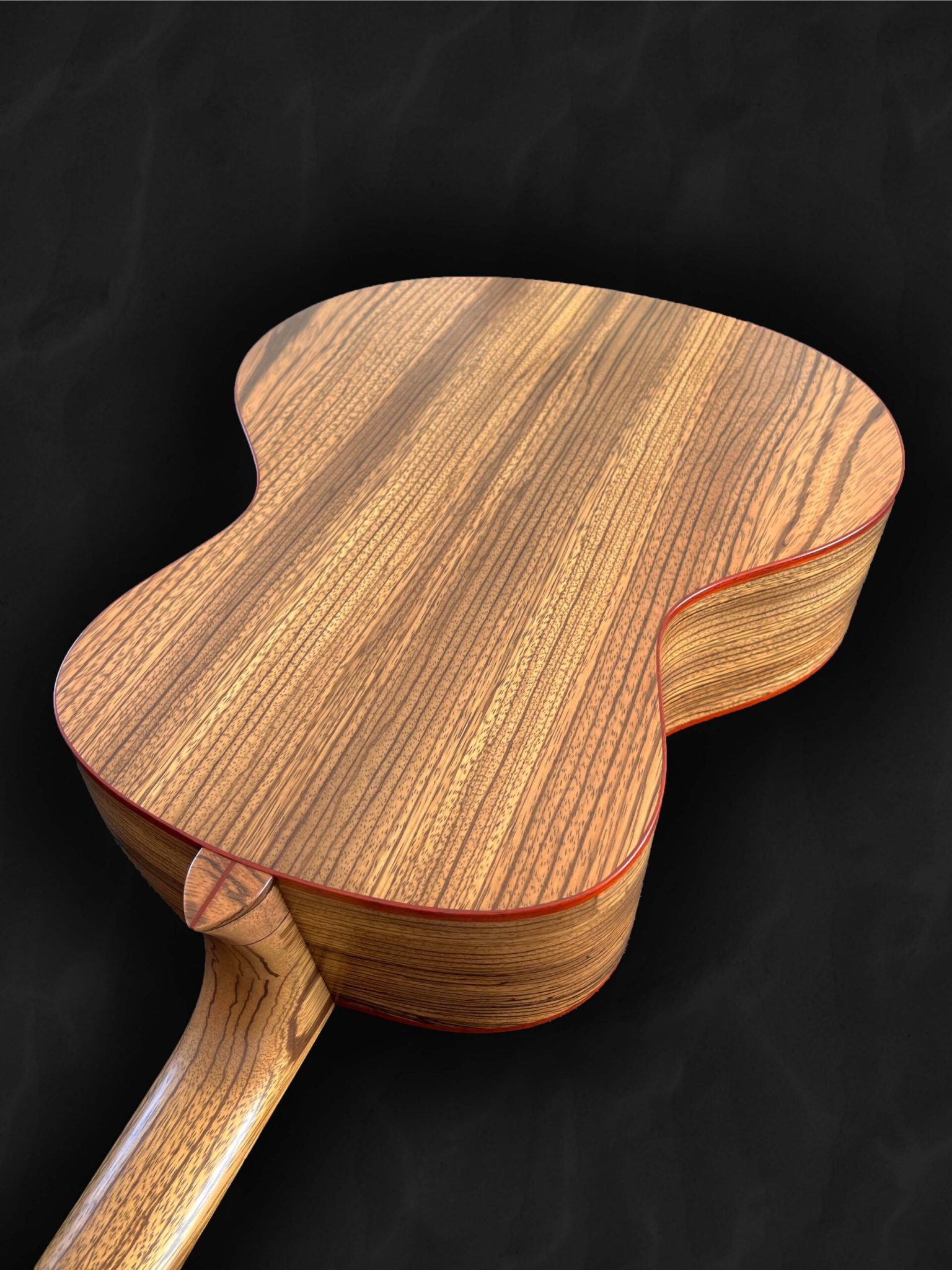 Guitare acoustique jumbo avec ouverture sur le côté, orientée vers le musicien en bois clair épicéa du Jura, Zebrano et liseré rouge